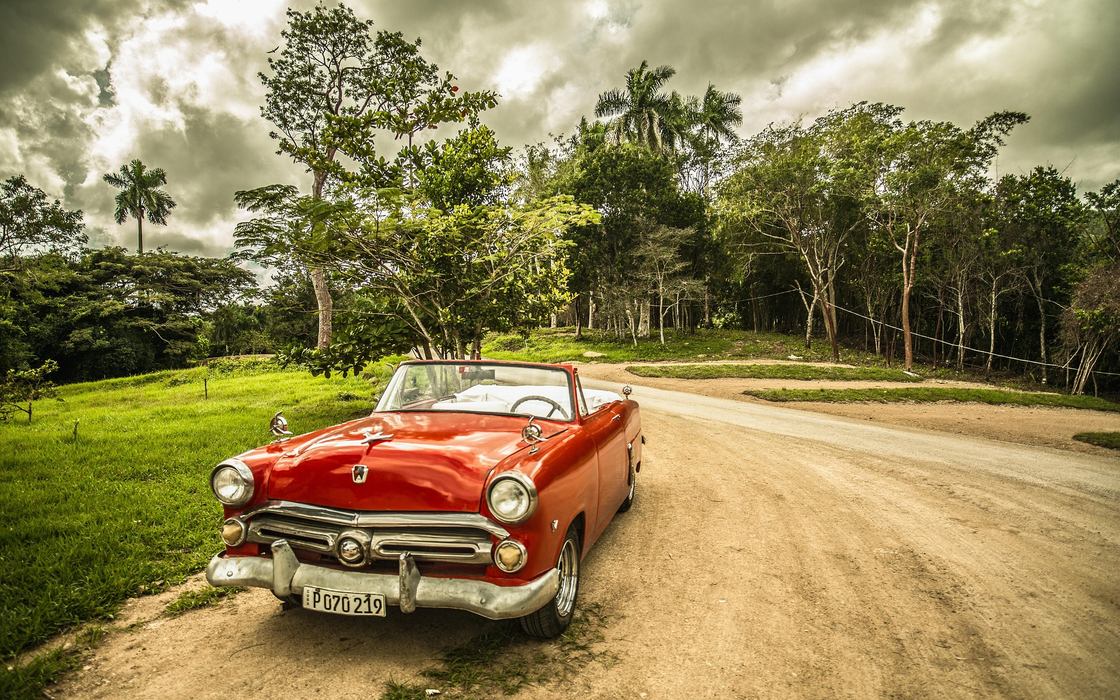 A classic car on an open road, moving forward