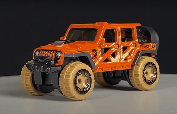 An orange Hot Wheels Jeep Wrangler with off-road tires